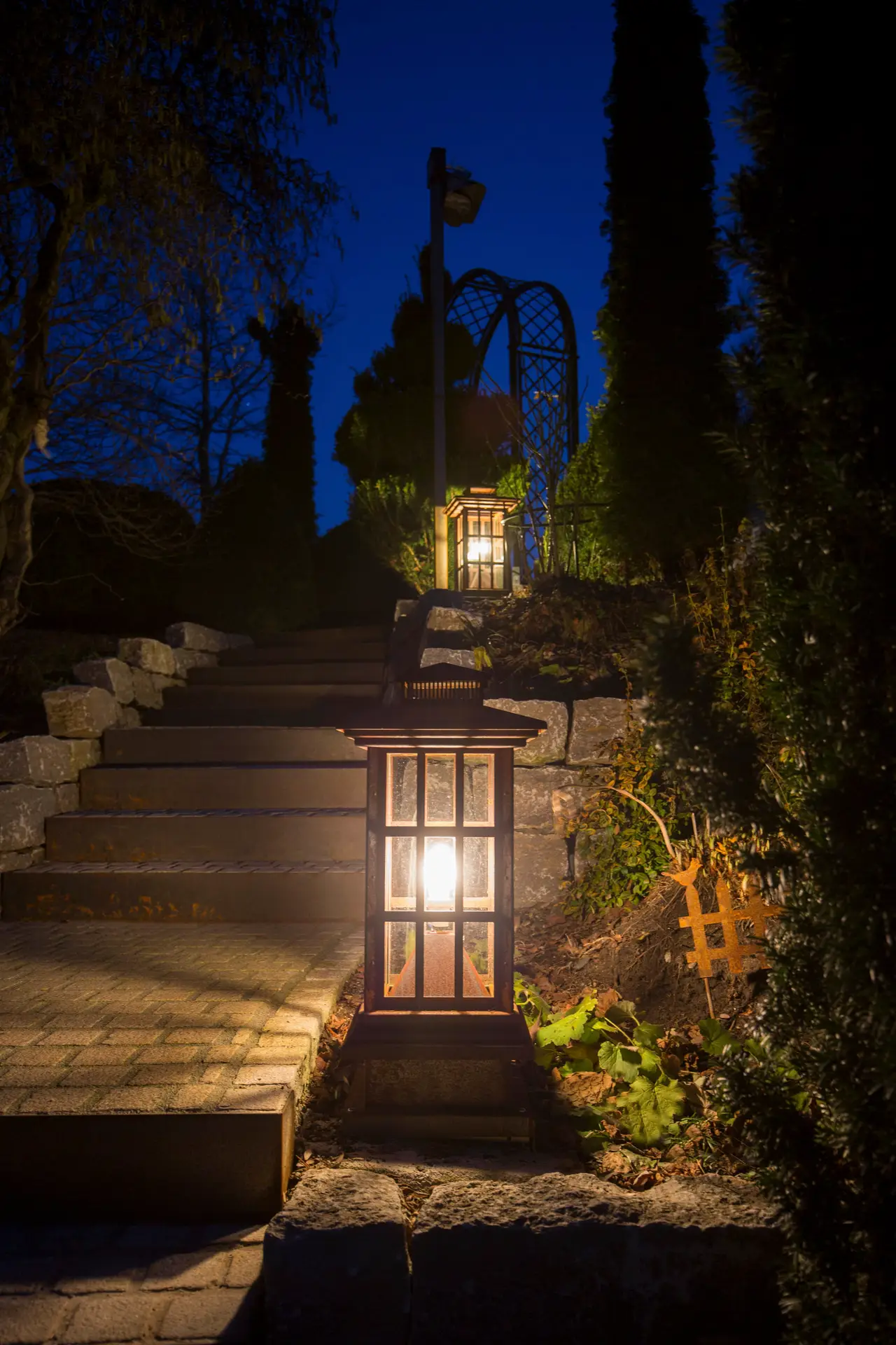 Beleuchtete Gartenlaterne aus Cortenstahl bei Nacht