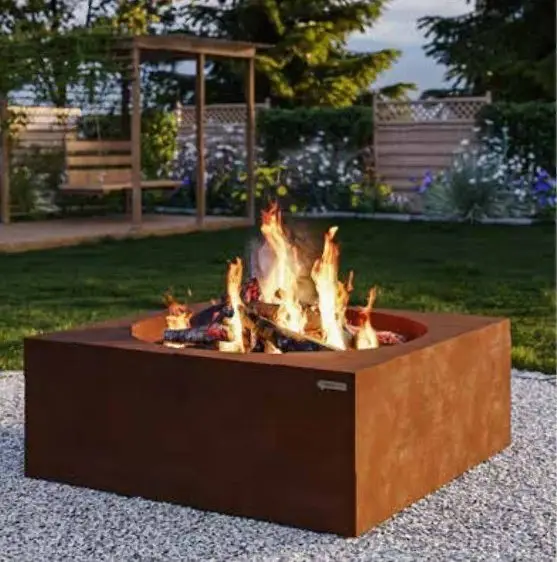 Feuerschale aus Cortenstahl mit brennendem Holz im Garten
